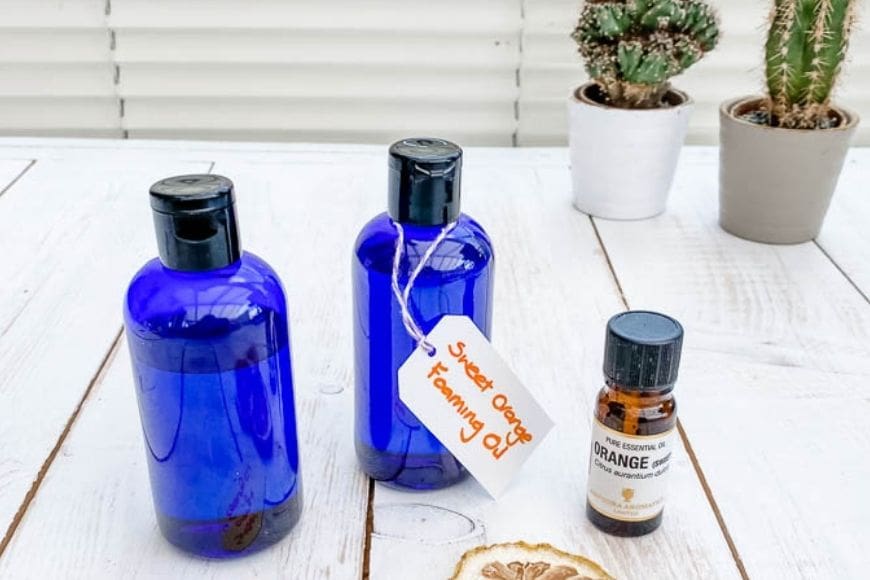 Two blue bottles with orange essential oil