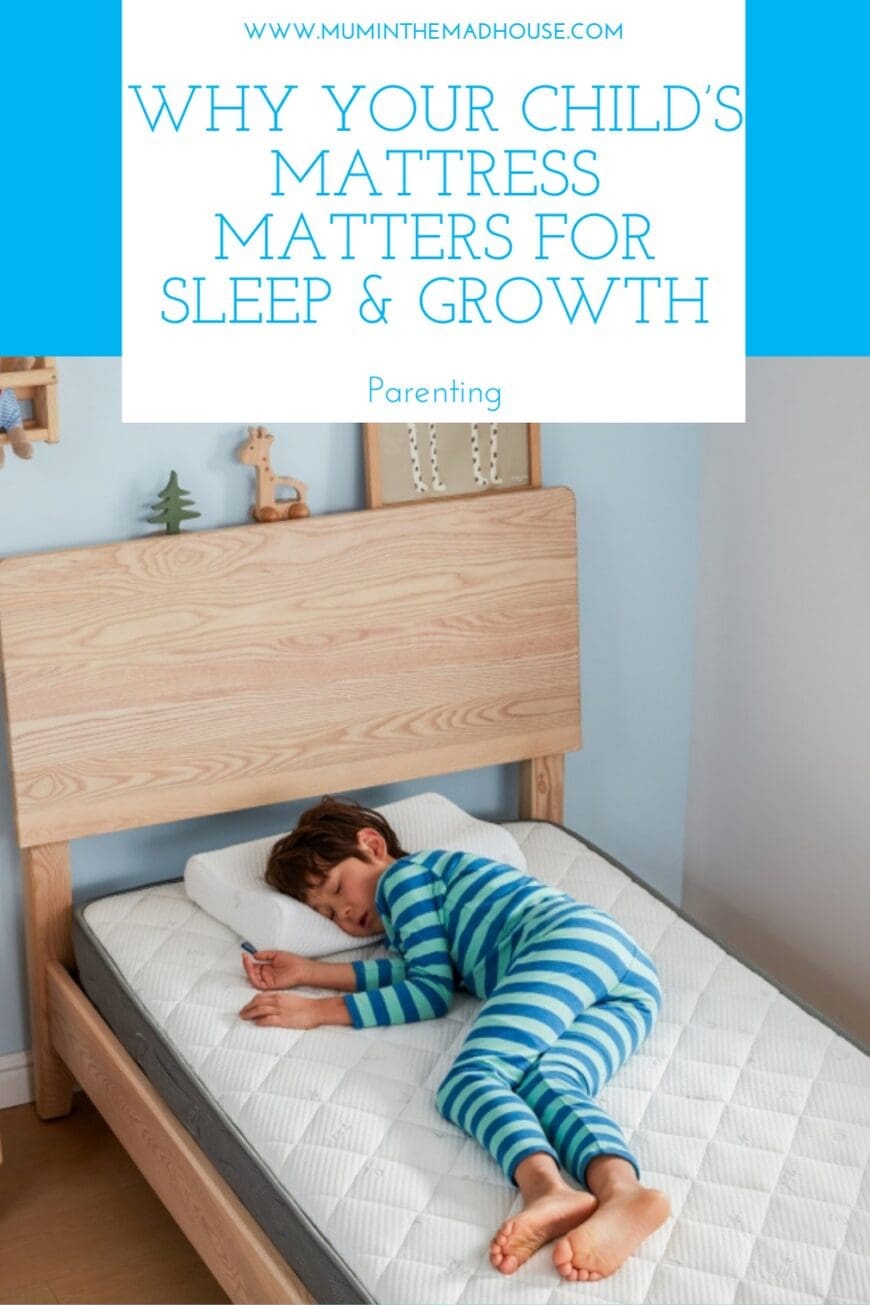 A young child in blue-striped pajamas sits on the floor in a neatly organized bedroom, playing with wooden toys. The room features a wooden bed with a white mattress, a nightstand with books and a plant, and a bright yellow lamp, creating a peaceful and inviting sleep space.